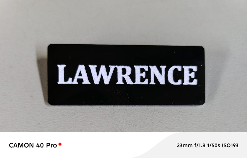 Custom engraved black name badge with white text LAWRENCE